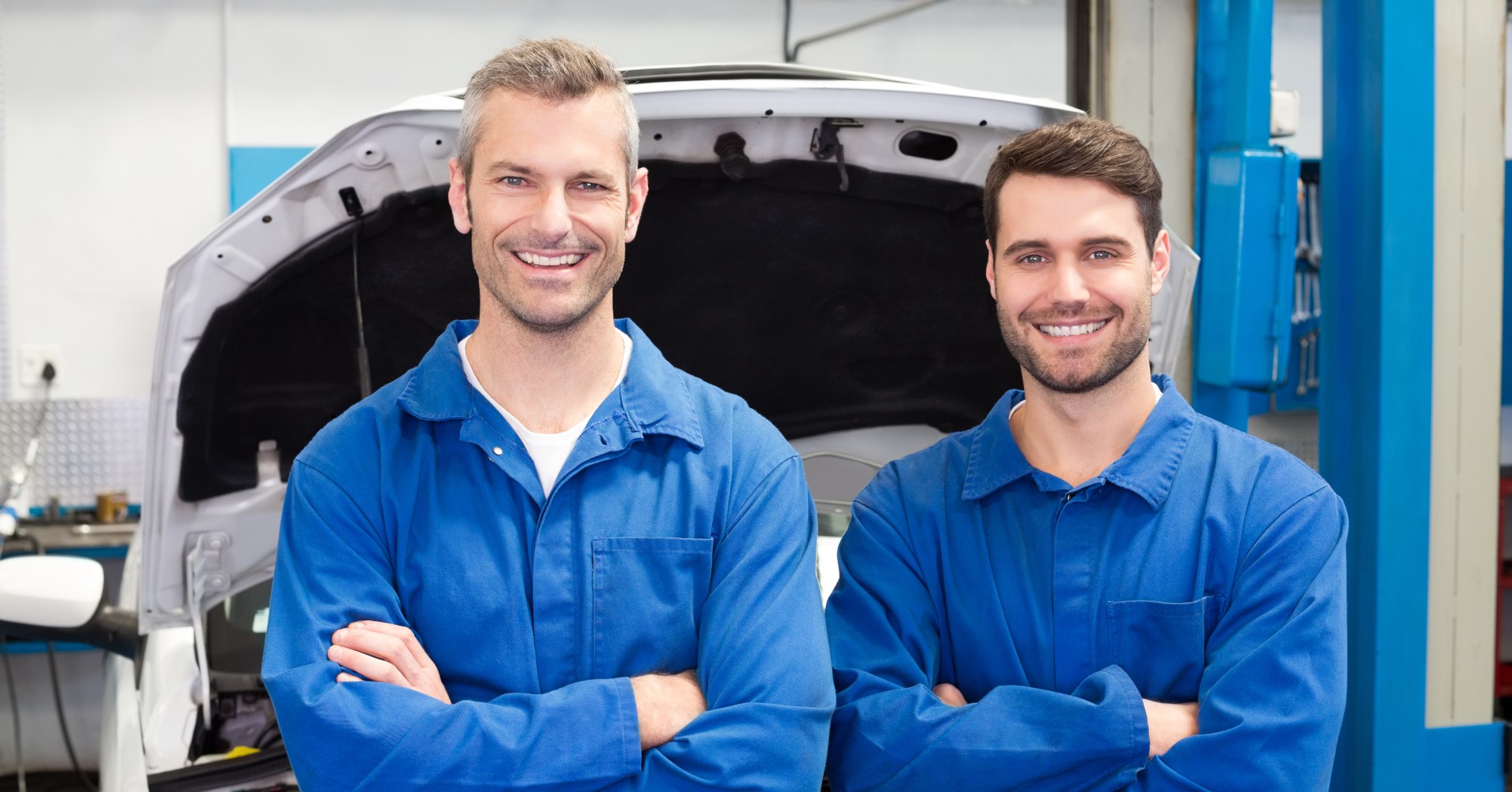 meccanici con tuta da lavoro che sorridono